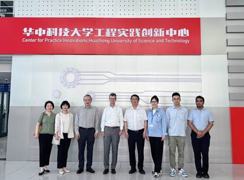 A group of people standing in front of a signDescription automatically generated